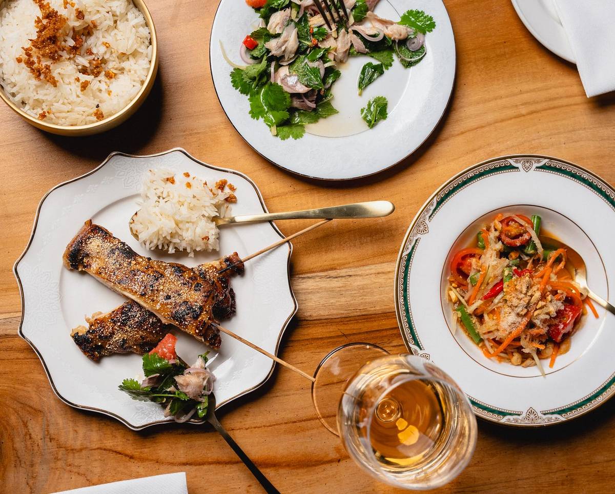 bangkok diners club dishes chicken skewers, papaya salad and chicken fat rice