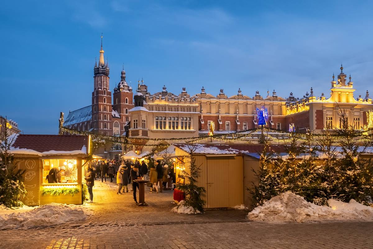 Krakow, Poland - December 5, 2024: Traditional Christmas fairs on the Main Market Square in Cracow, Poland. Beautiful Christmas stall and holiday illumination. Mariacki church and Cloth hall in Krakow
