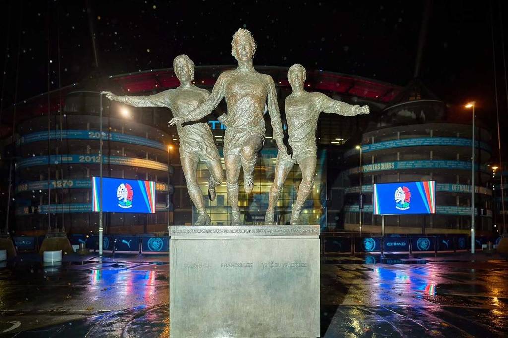 statues outside etihad stadium in manchester with signs saying manchester euro 2028