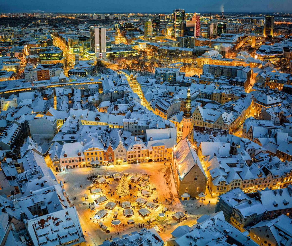 tallinn christmas market and old town lit up at night with snow on roofs
