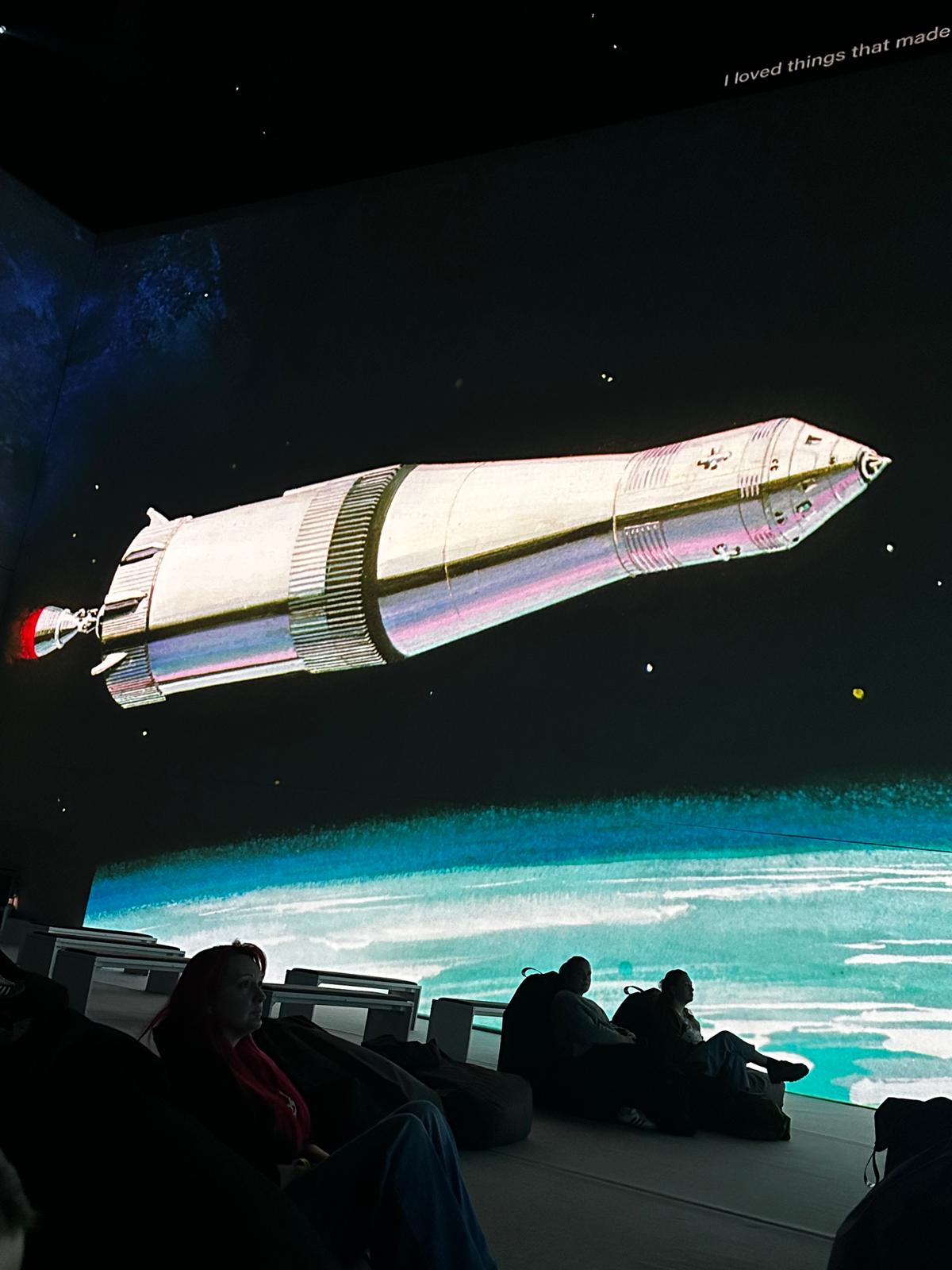 projection of rocket drifting past earth on screen