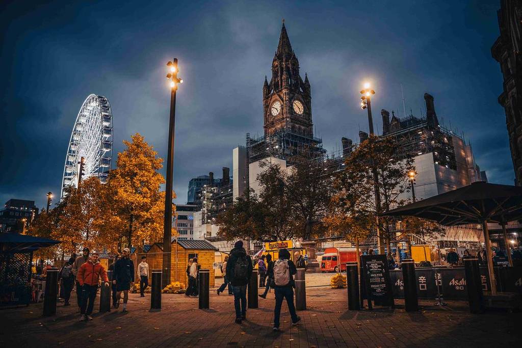 view of manchester town hall and christmas markets at albert square at night
