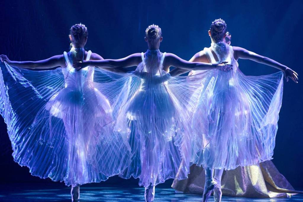 Three dancer perform in glowing costumes at Ballt of Lights.