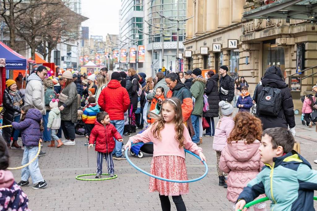 child with hula hoop in st ann's square, manchester as part of super duper family festival