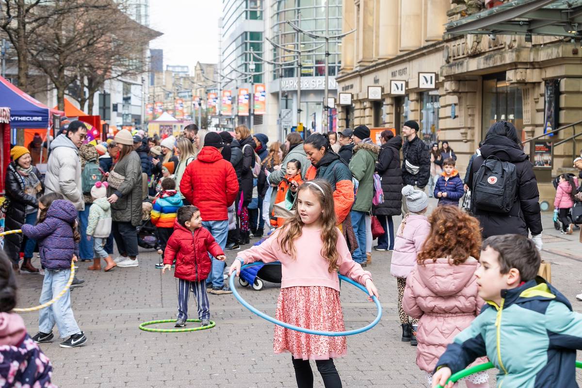 child with hula hoop in st ann's square, manchester as part of super duper family festival