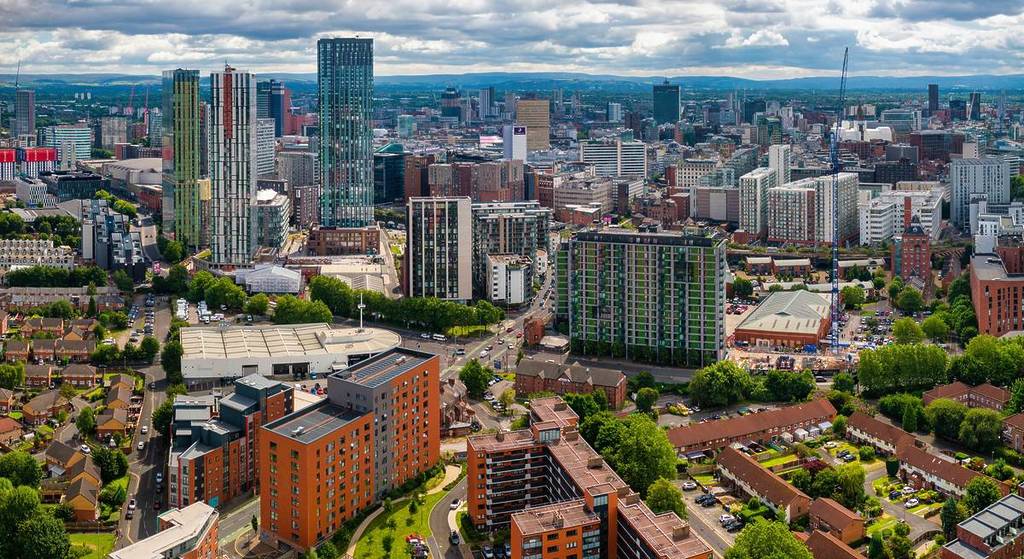 Manchester, Greater Manchester, United Kingdom. July 23, 2024. Aerial view of Manchester cityscape with skyscrapers and construction sites