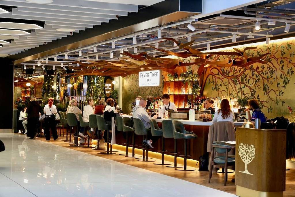 people sat at fever-tree premium bar at manchester airport terminal 2