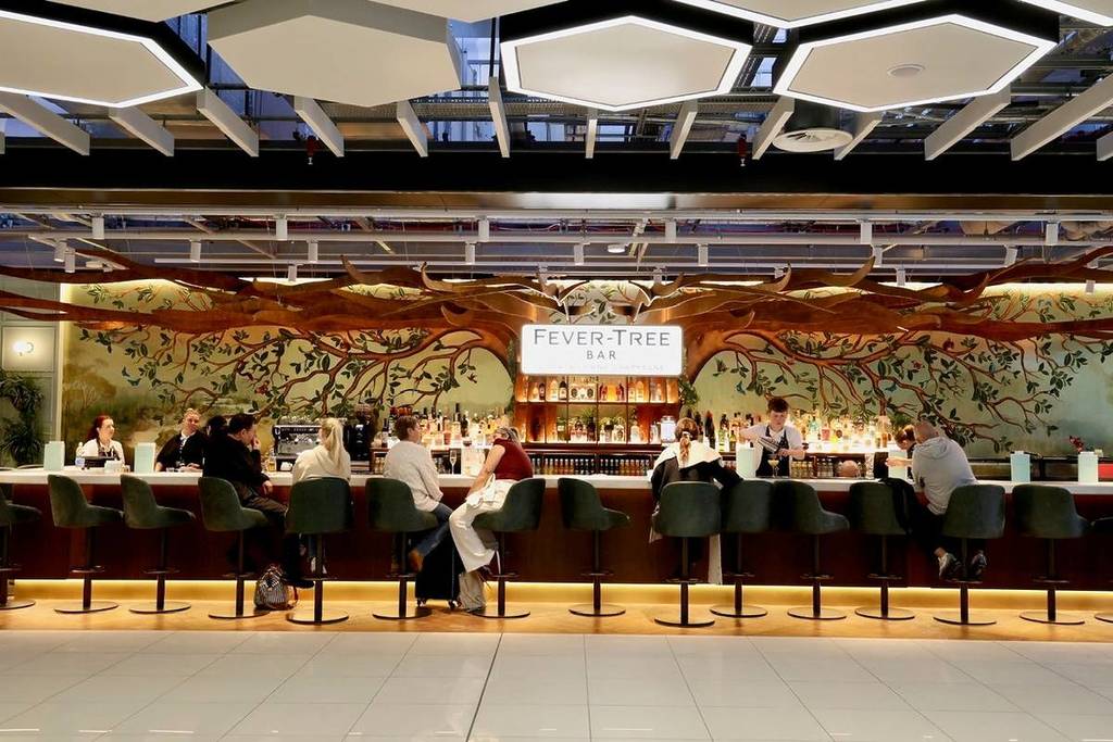 people sat at bar on velvet blue stools at terminal 2