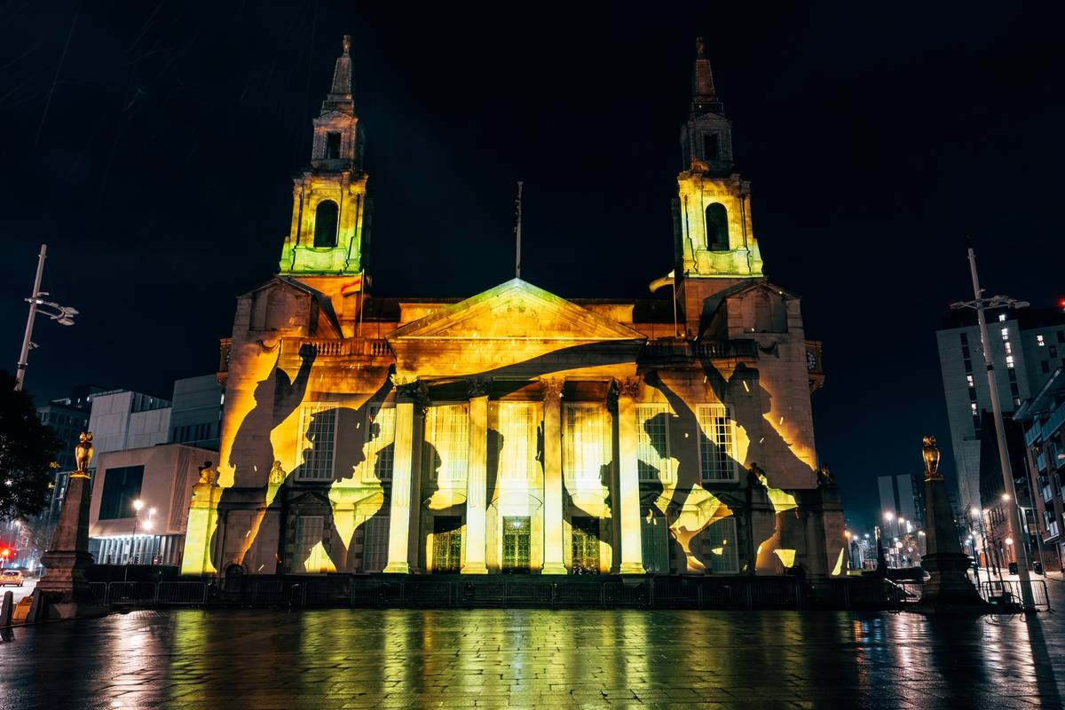 leeds civic hall lit up in yellow with cyclists to celebrate hosting tour de france 2027