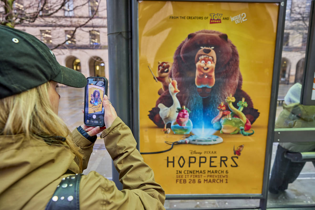 person taking photo of Hoppers poster in Manchester