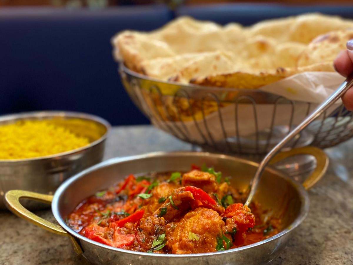 reaper karahi curry with chicken and poppadoms next to it