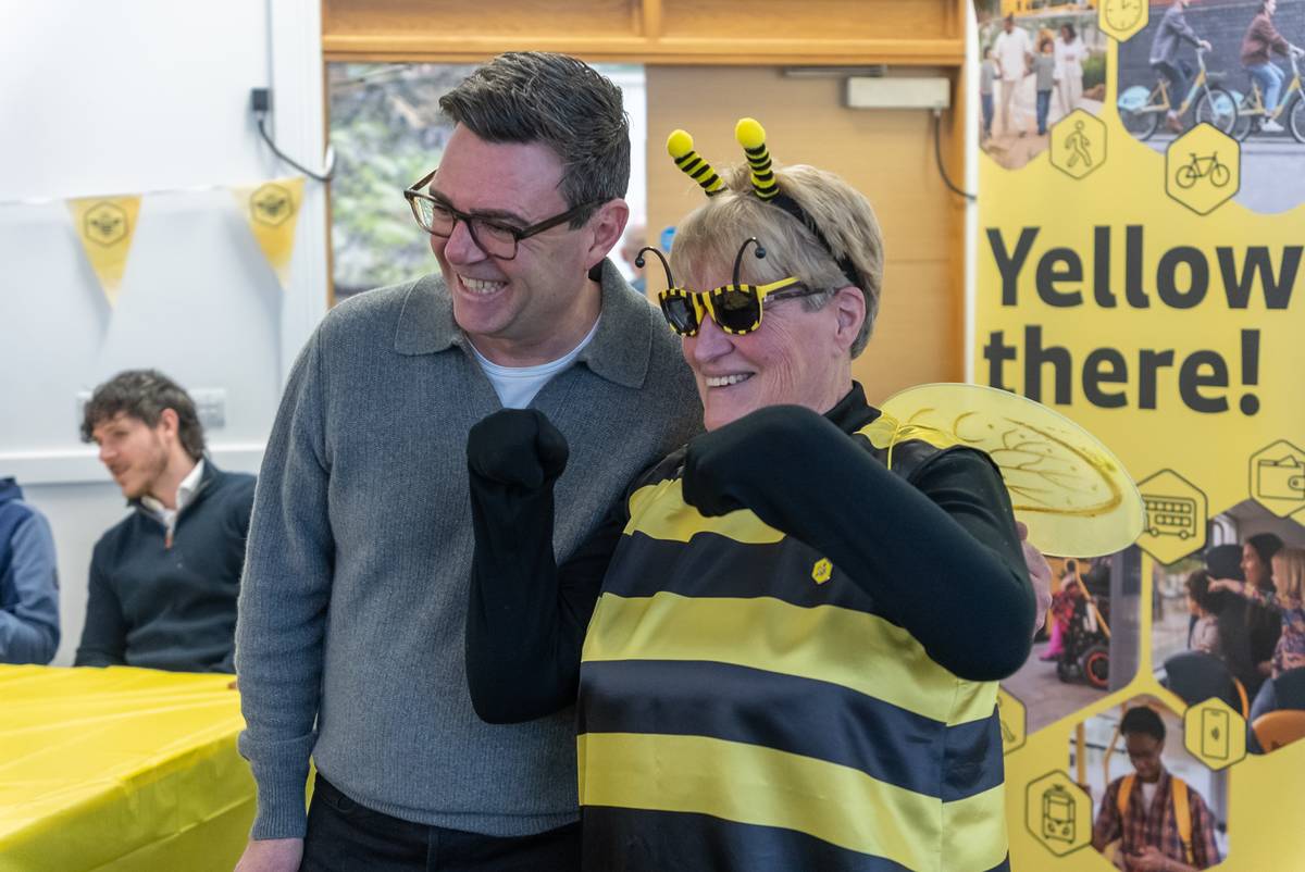 andy burnham next to woman dressed as a bee