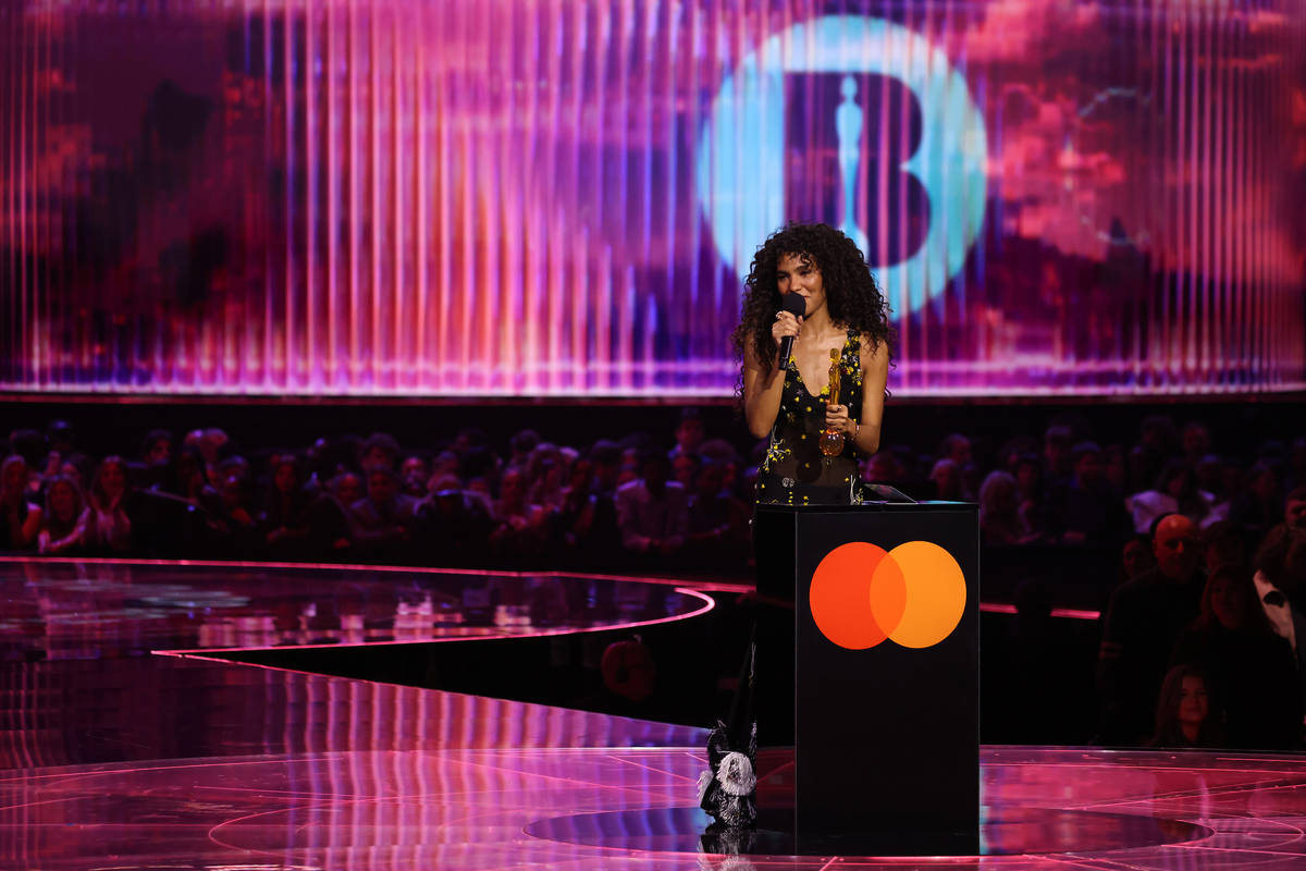 olivia dean on podium with brit award