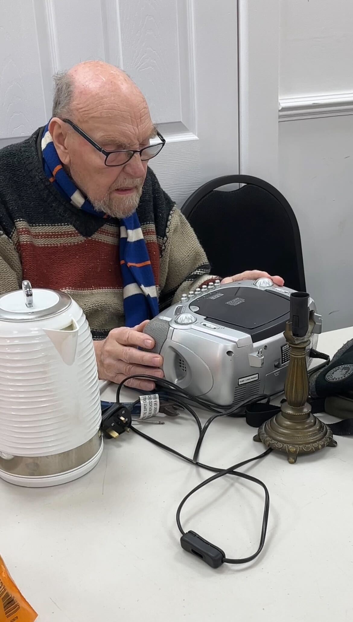 elderly man fixing cd player