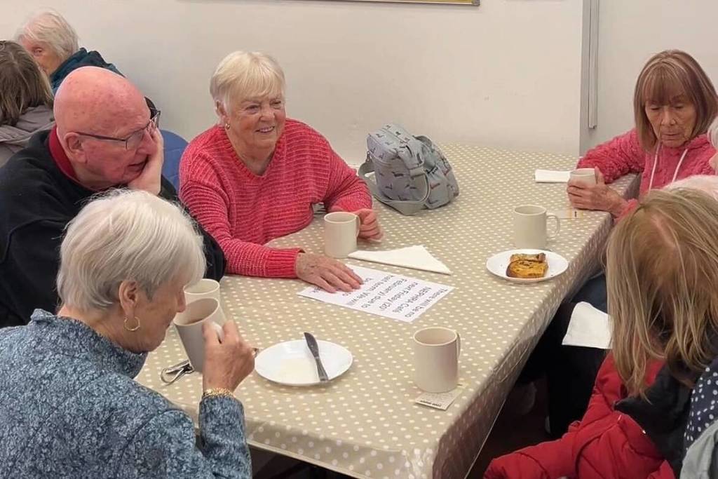 people sat at table with cups of tea at NEPHRA Repair Cafe in Manchester
