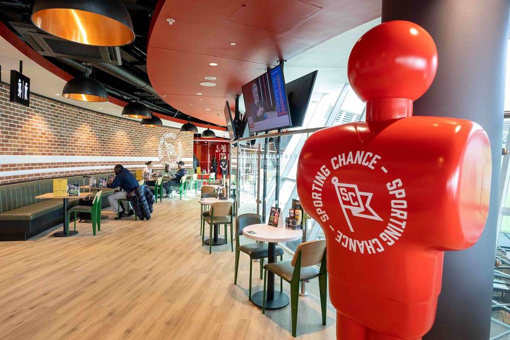 red figure statue saying sporting chance inside sports bar