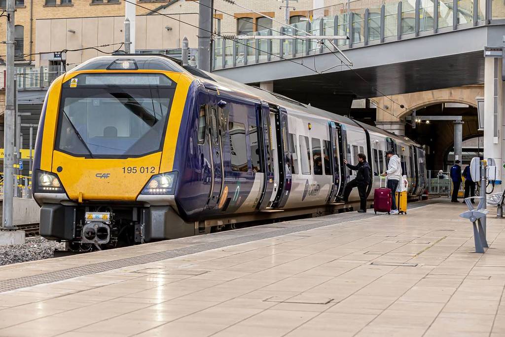 Northern train at platform with doors open at Manchester Victoria station