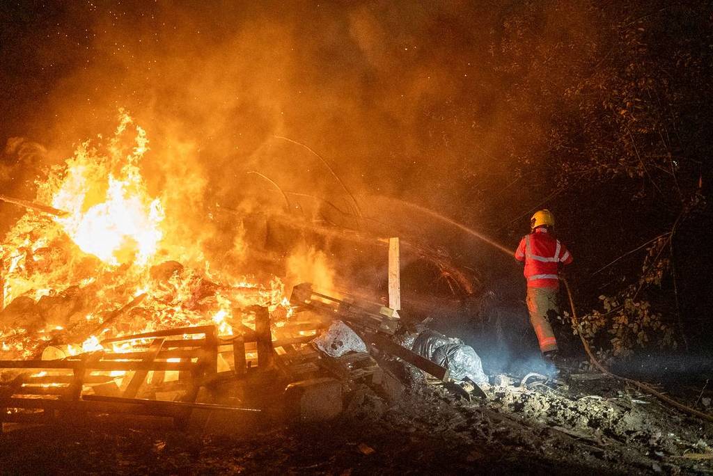 gm firefighter putting out fire with hose in forest area