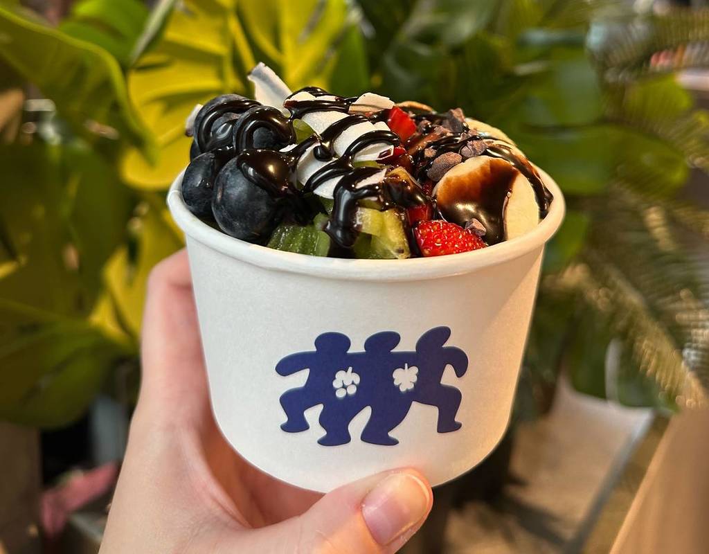 acai bowl yopped with blueberries, banana, kiwi, strawberries and chocolate sauce