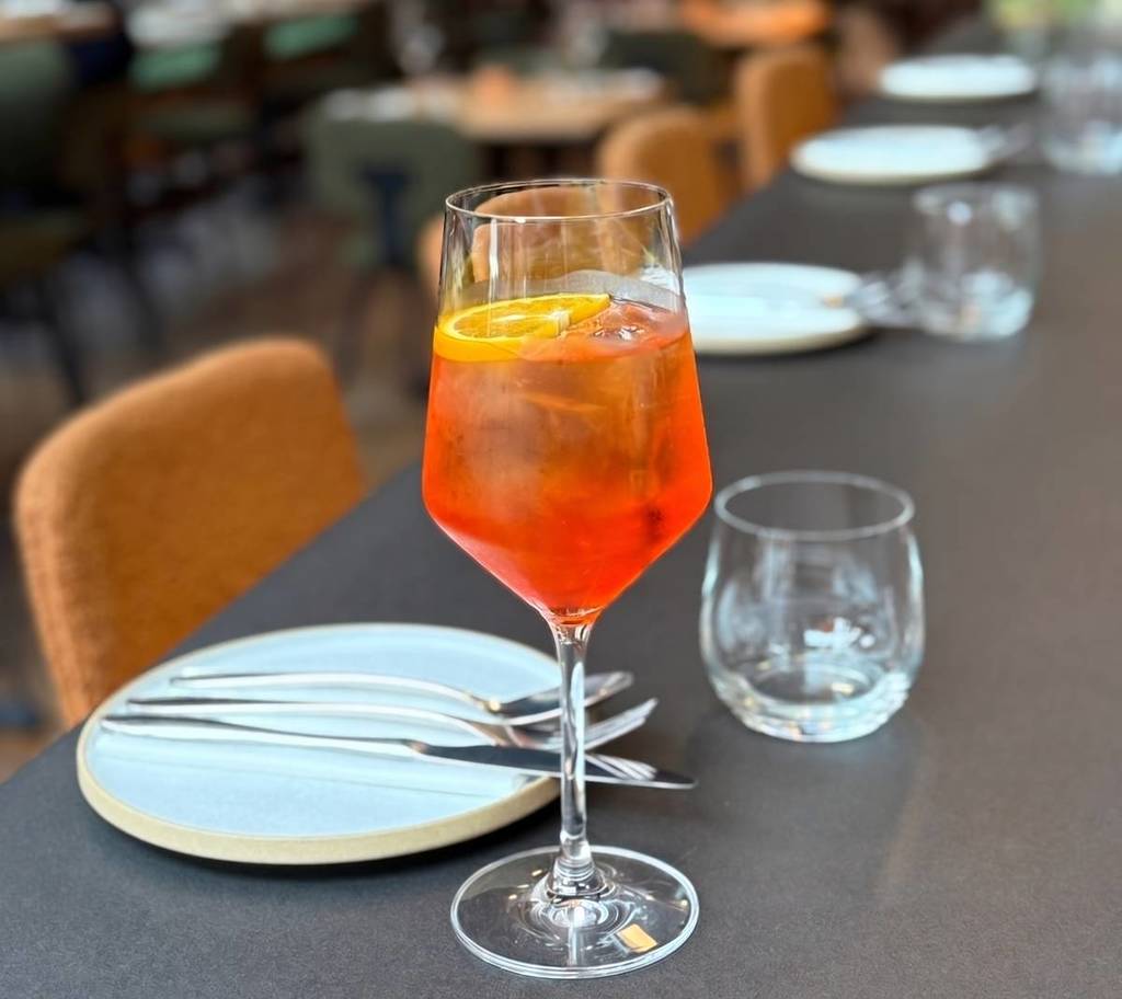 an aperol spritz on a freshly laid restaurant table