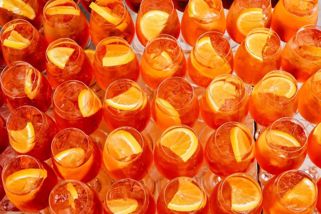 aperol spritzes filling a tabletop seen from above