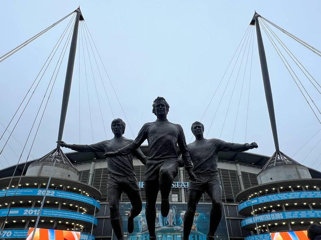 three statues of footballers outside manchester city etihad stadium
