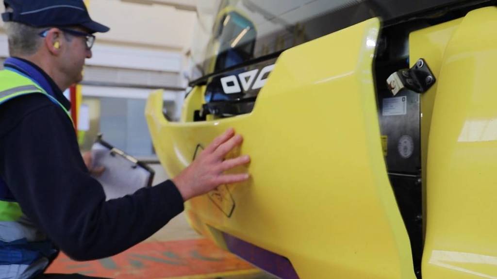 man closing front of yellow bus