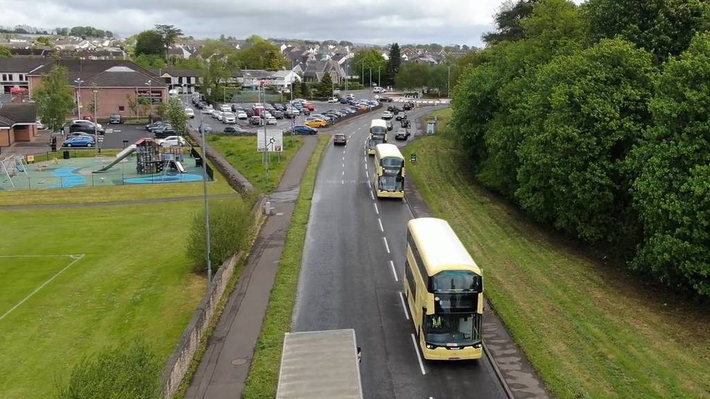 yellow buses driving down road