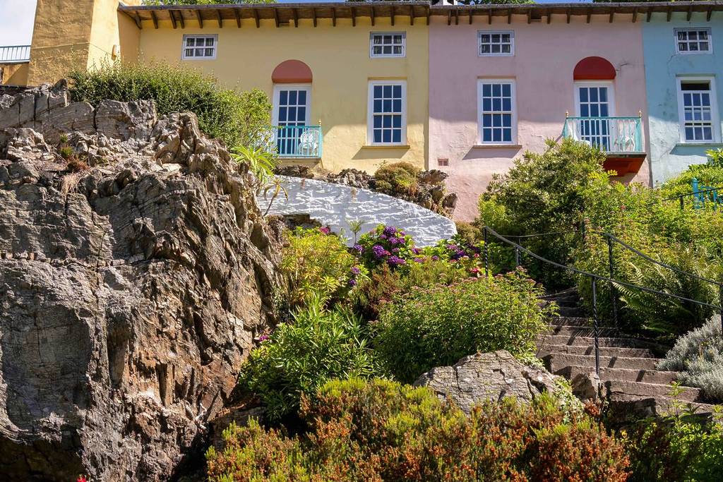Gardens, rocks and coloured houses during summer at Portmeirion, Wales, UK.