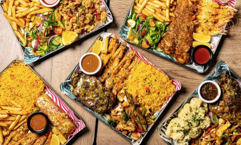 selection of seafood platters with rice and fries shot from above
