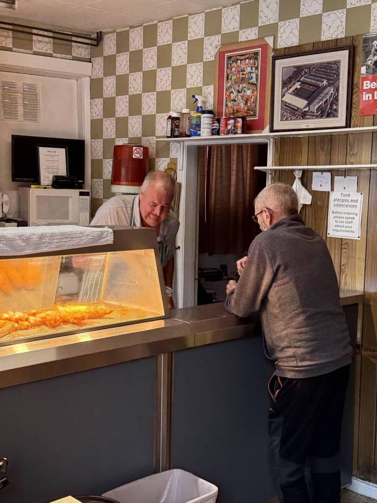 inside robbins j chippy in leigh with customer at counter