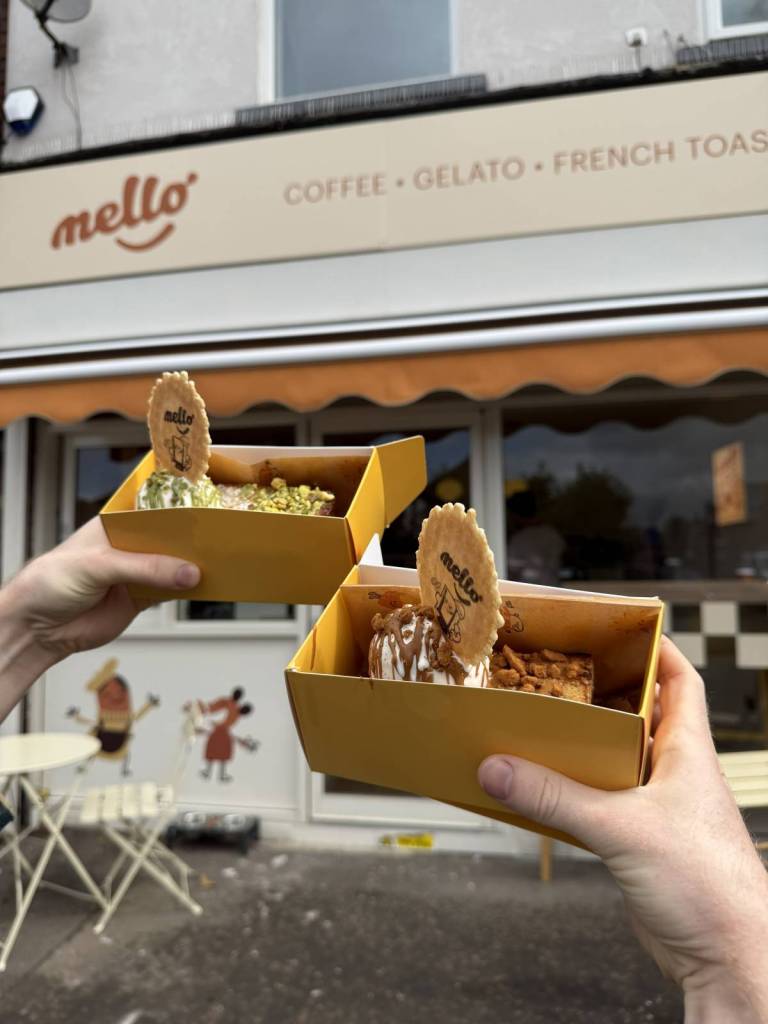 two french toast  takeaway boxes held up outside mello in didsbury