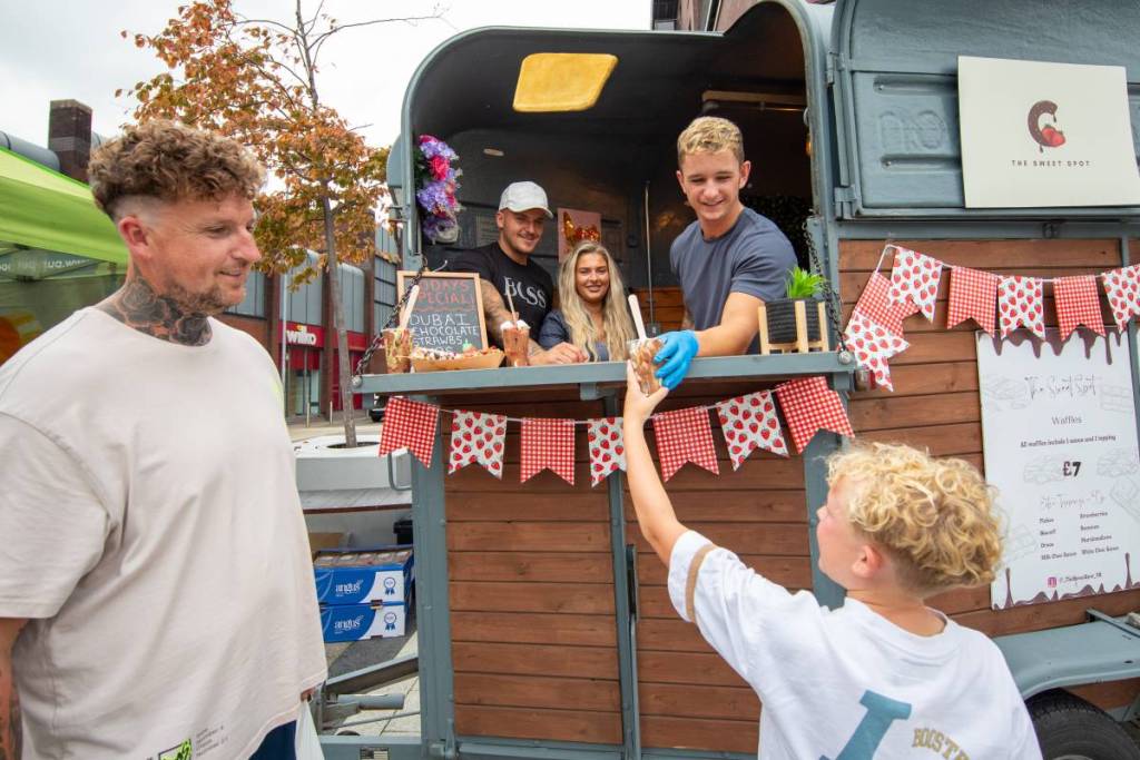 child taking ice cream sundae from cart at bury food and drink festival