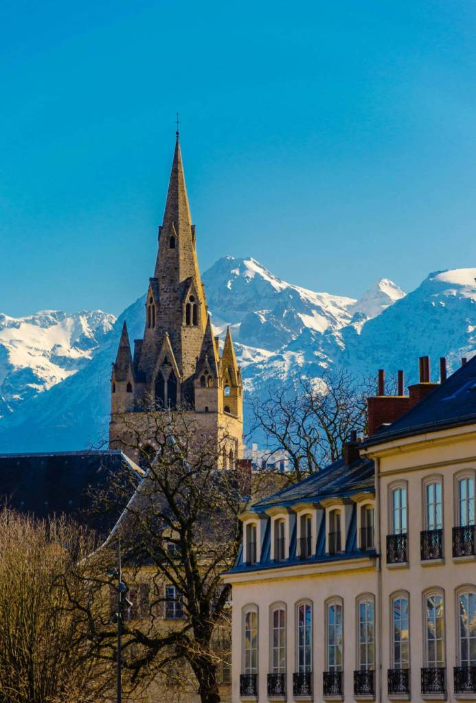 church spire with alps in background in grenoble, france - one of the destinations in jet2.com ski programme from manchester airport