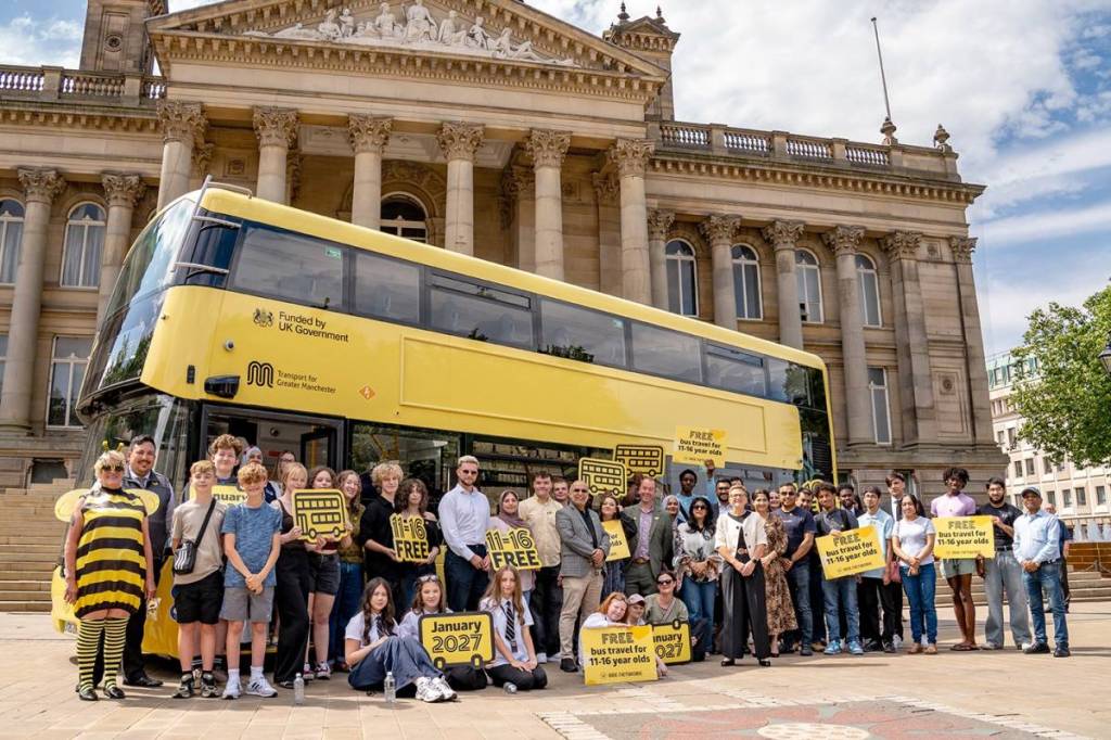 children stood in front of yellow bee network bus in Bolton