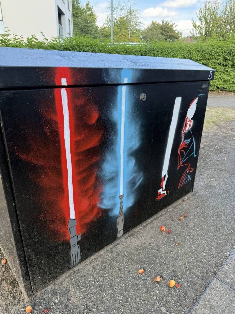 electrical box with three lightsabers spray painted on
