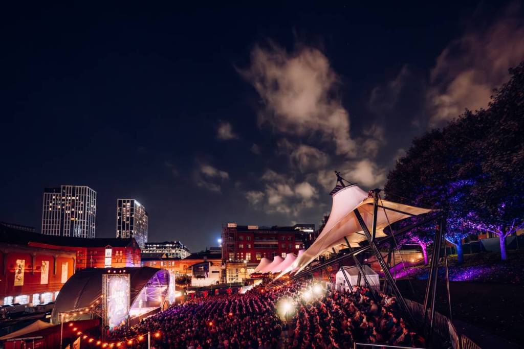 audience sat in castlefield bowl, manchester at night