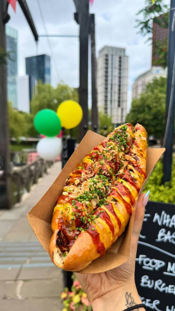hot dog held up outside the wharf, castlefield, manchester