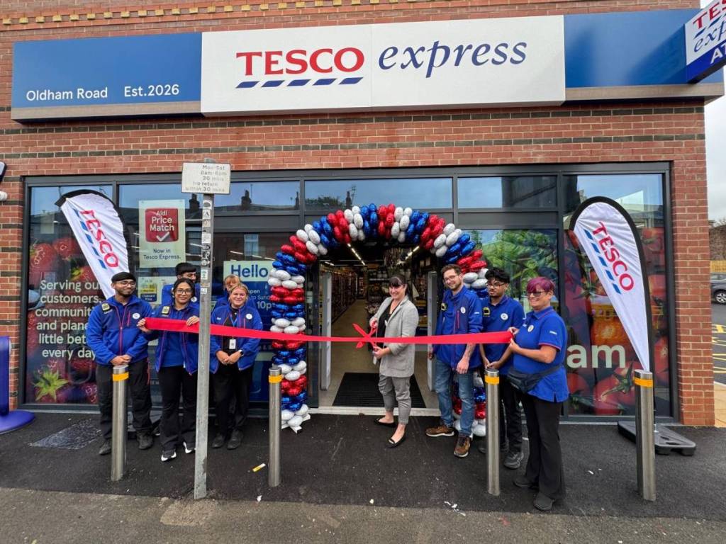 staff cutting the ribbon to new tesco express store on oldham road, rochdale, greater manchester