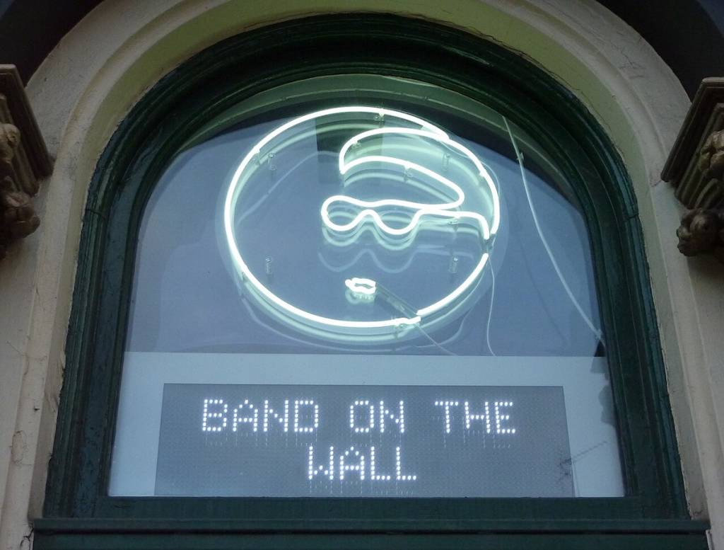 neon sign outside band on the wall