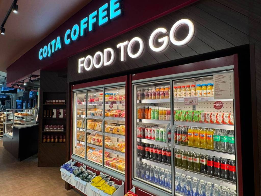 fridges with selection of drinks and sandwiches inside with sign up saying food to go