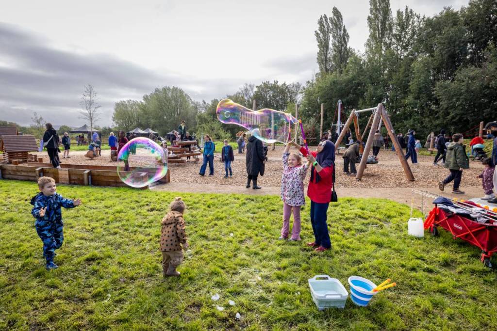 childre in northern roots playground with bubbles in air