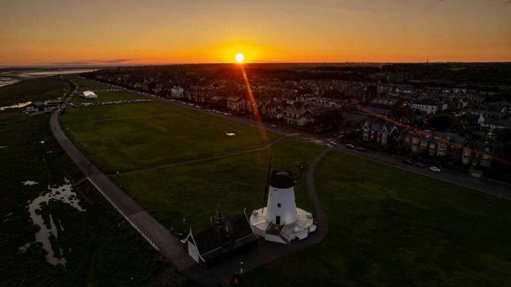 view of lytham town with windmill by meach at sunset