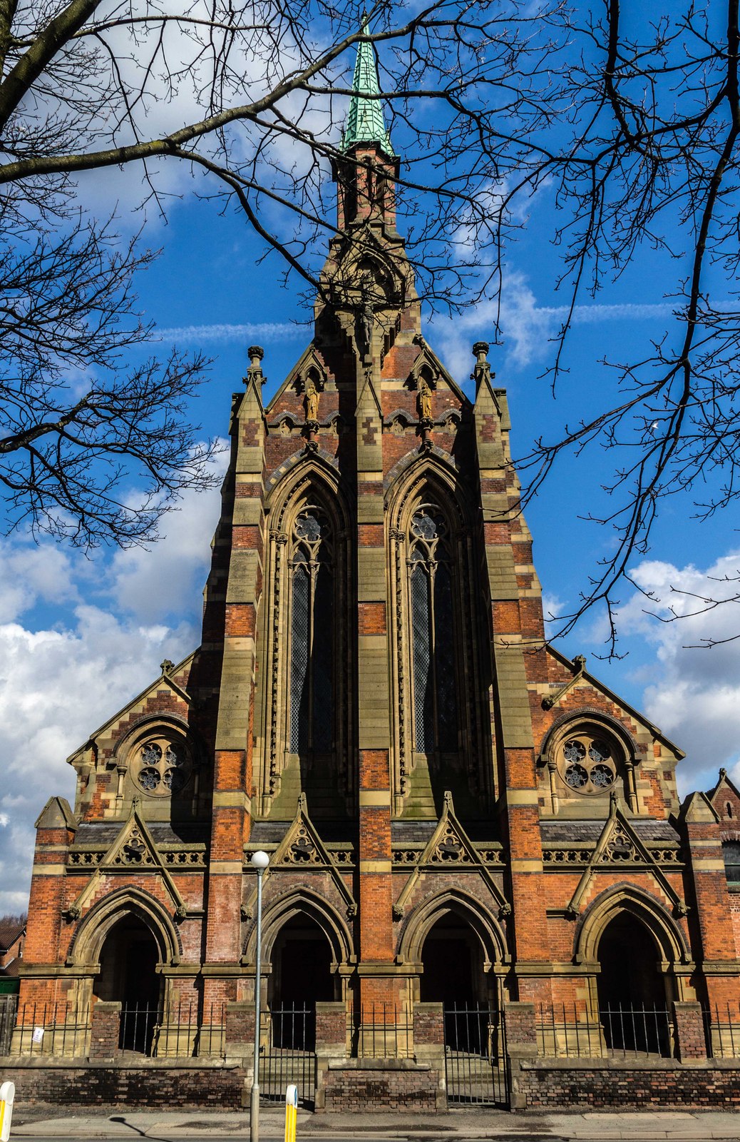 exterior shot of gorton monastery, manchester front on with blue skies and tree branches in background