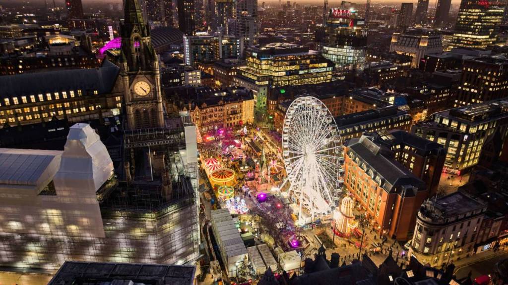 view over albert square at night at manchester christmas markets with ferris wheel and town hall