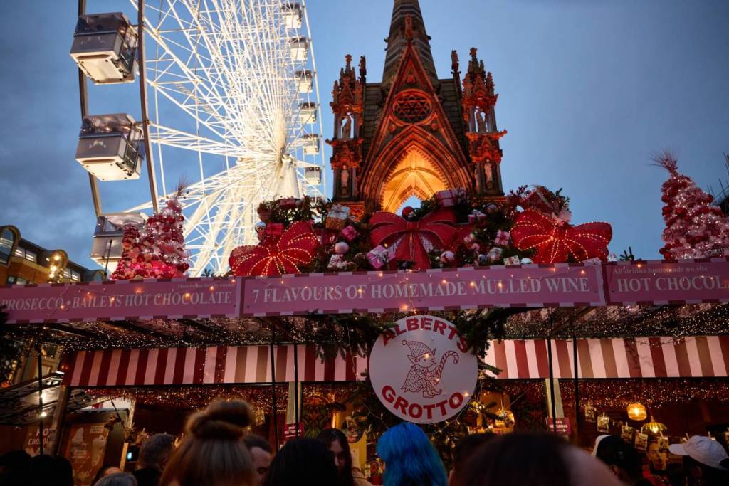 albert square at night with french toast market stall and ferris wheel and statue in background
