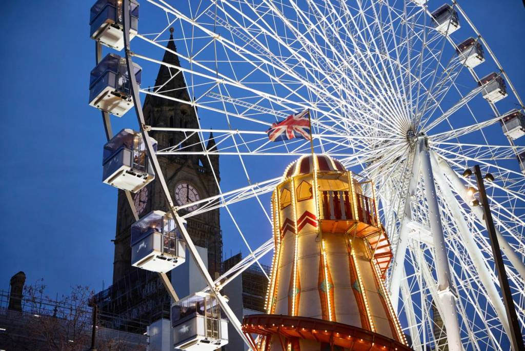 view of helter skelter, town hall and ferris wheel in albert square, manchester