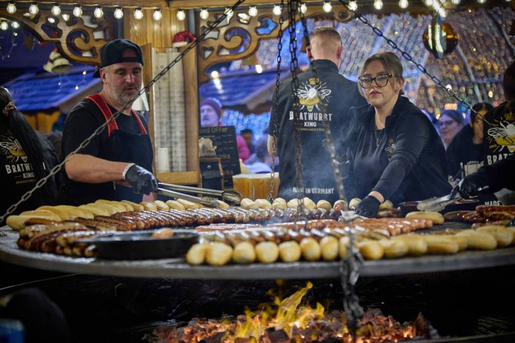 swing grill with traditional German bratwursts on at manchester christmas markets