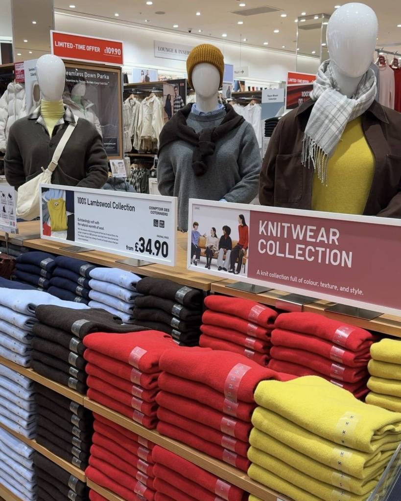 different coloured folded cashmere jumpers on shelves with three upper body mannequins behind at uniqlo trafford centre