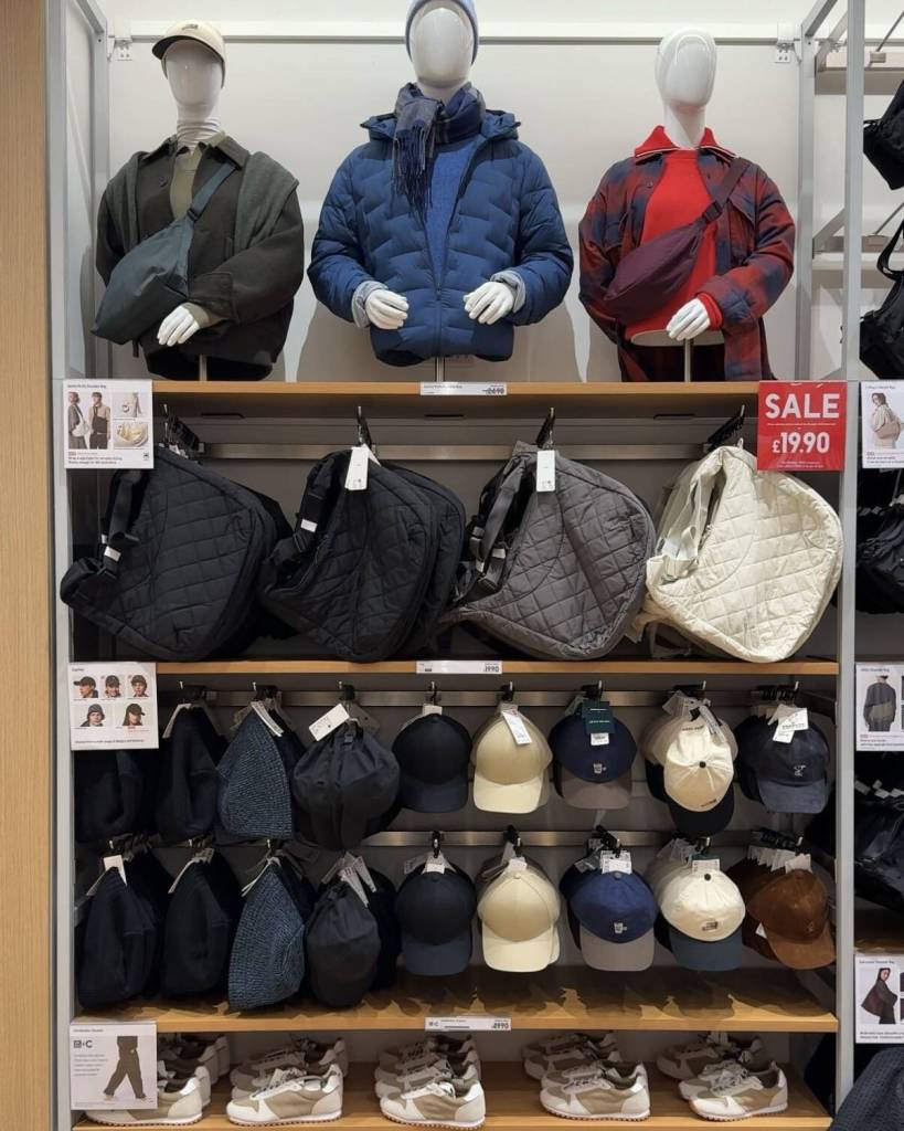 rows of uniqlo bags and hats on hooks